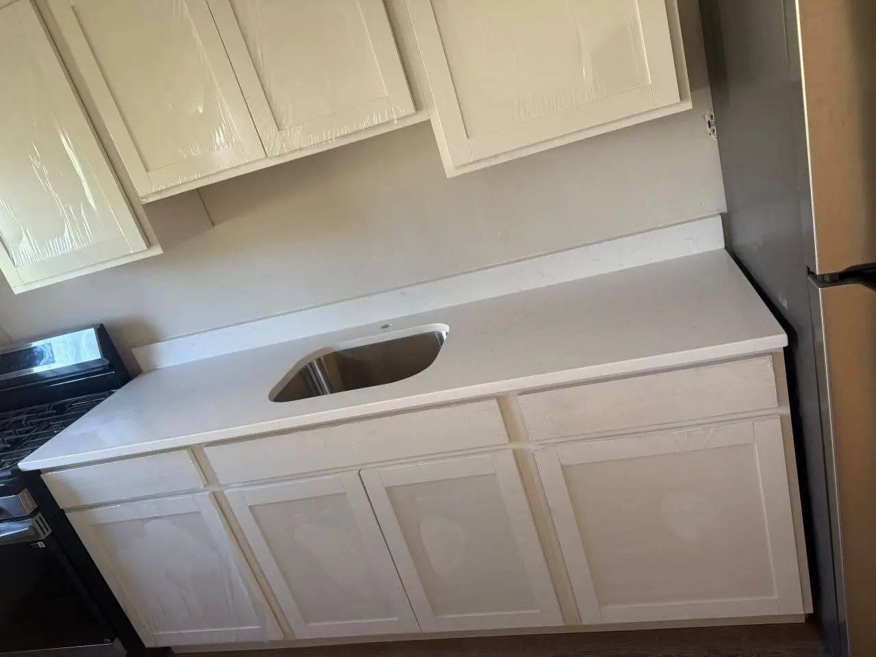 White countertop and low backsplash installed over white cabinetry